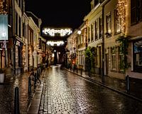 Een knus straatje in Breda na een regenbui, waardoor de lichten mooi reflecteren op de straat.