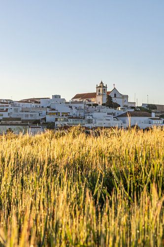 Zandstrand in de ochtend met uitzicht op het historische centrum van Ferragudo, Portimão, Algarve, Portugal