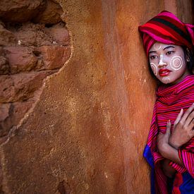 Girl sells cotton scarves at the ruins of pagodas in Myanmar Inle. She has Thanaka makeup on her fac