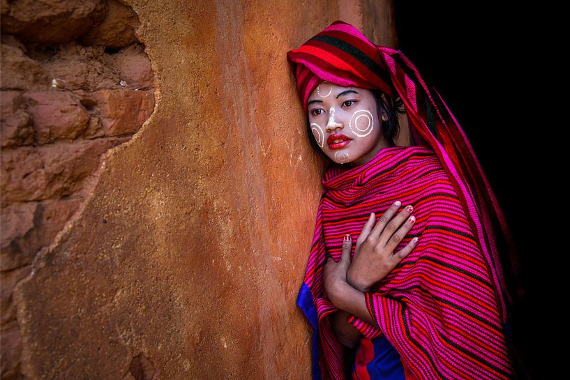 Girl sells cotton scarves at the ruins of pagodas in Myanmar Inle. She has Thanaka makeup on her fac by Wout Kok