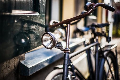 Old classic black men's bicycle parked against old house
