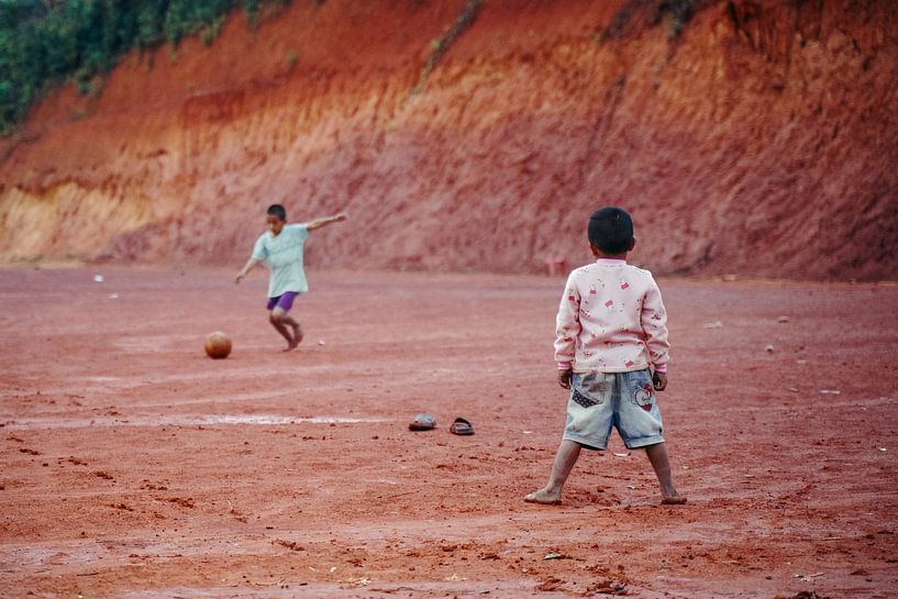 Two little boys playing soccer in Laos by Floris Verweij