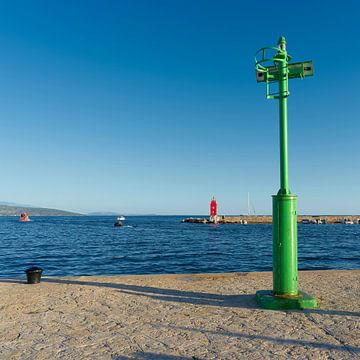 green lighthouse in the port of the town of Krk in Croatia by Heiko Kueverling