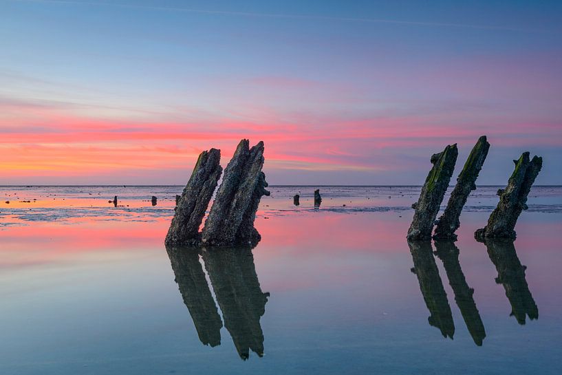 Einstellungssonne über Pfosten an den Gezeiten- sandflats am Ende des Tages von Sjoerd van der Wal Fotografie