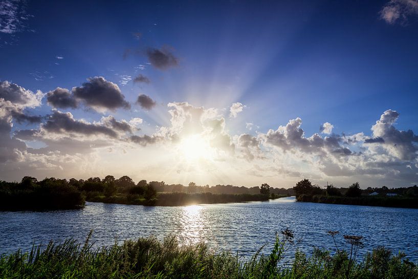 Sunbeams from behind the clouds over the water by R Smallenbroek