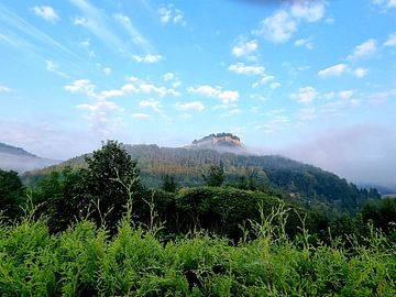 Weiße Schäfchenwolken am azurblauen Himmel über der Festung Königstein von Claudia Schwabe