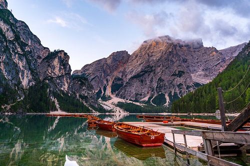 Wooden boats line the shoreline of Pragser Wildsee, Braies Lake, in the stunning Dolomites of South Tyrol, Italy