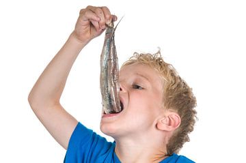 jongen eet een haring van Marcel Mooij