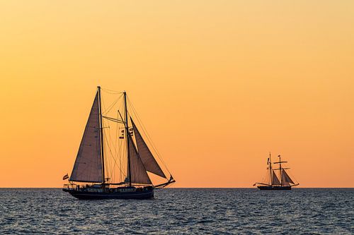 Zeilschepen in de zonsondergang bij de Hanse Sail in Rostock