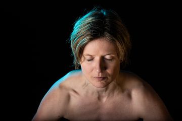 Low key studio portrait of a 35 year old white woman with naked