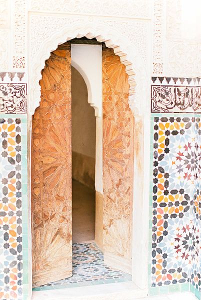 Houten deur omringd door kleurrijke tegels in een paleis in Marrakesh van Anouschka Rokebrand Photography LLC