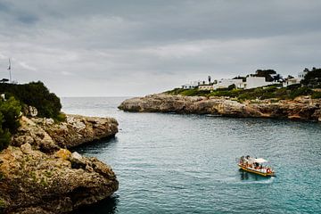 Zeezicht Mallorca, Spanje | Foto van  een vissersboot op de middellandse zee tussen de rotsen | Euro