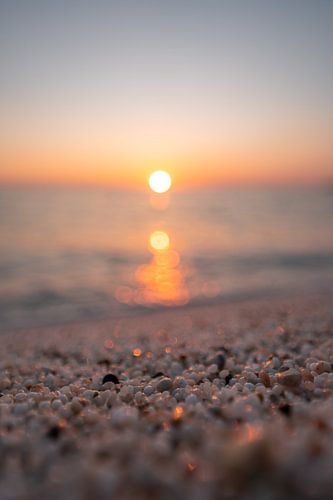 Risottorijst op het strand van Is Arutas in Sardinië bij zonsondergang met glinsterende zee en stenen