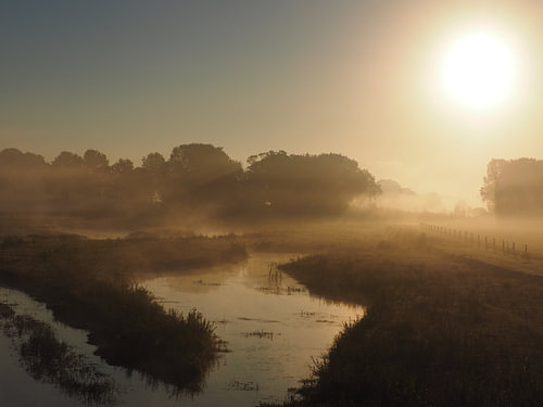 Mistige zonsopkomst boven het water