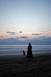 Een teder moment aan zee bij zonsondergang