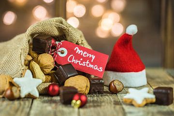 Christmas food and sweets with tag Merry Christmas and sparkling lights background by Alex Winter