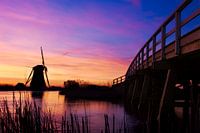 Molen en brug tijdens kleurrijke zonsopkomst