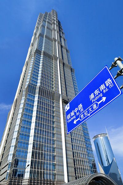 Shanghai Jinmao Tower with traffic signage and blue sky by Tony Vingerhoets