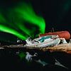 Noorderlicht (Aurora Borealis) boven een scheepswrak en weerspiegelt in het water van Martijn Smeets