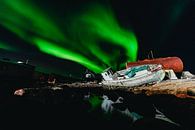 Noorderlicht (Aurora Borealis) boven een scheepswrak en weerspiegelt in het water van Martijn Smeets thumbnail