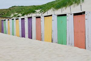 Een rij strandhuisjes met gekleurde deuren