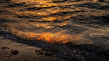 Brandend water bij ondergaande zon