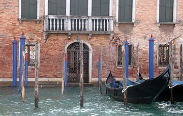 Gondels in Venetië met blauwe aanlegpalen. van Jan Katuin