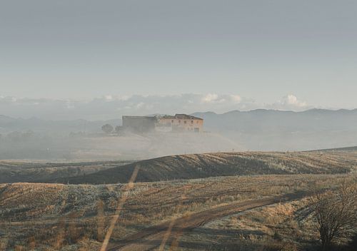 Maison de campagne toscane, abandonnée, se dressant seule et enveloppée dans la brume du matin.
