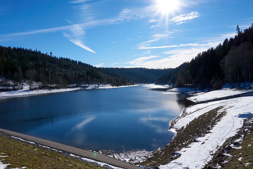 Beautiful panoramic view of the Nagoldtalsperre with water, sunshine, snow and blue sky by creativcontent