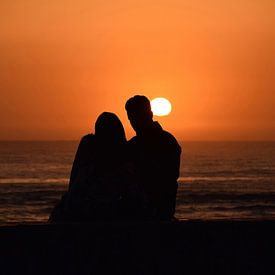 Verliebtes Paar, das auf den Sonnenuntergang starrt. von Steven Jacobs