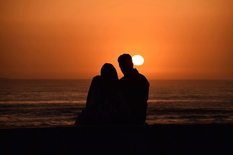 In love couple staring at the sunset by Steven Jacobs