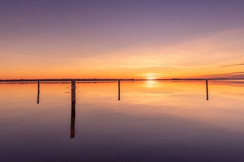 Sunset at the poles in the water at Surfstrand Belterwijde