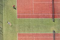 Tennis court in bird's eye view with a sunbathing girl and a tennis player
