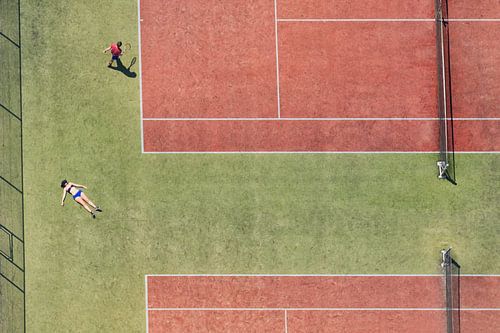 Tennis court in bird's eye view with a sunbathing girl and a tennis player
