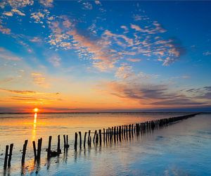 eindeloze paaltjes bij zonsondergang van Hillebrand Breuker