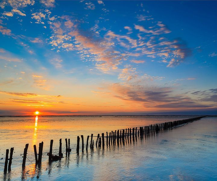 eindeloze paaltjes bij zonsondergang van Hillebrand Breuker