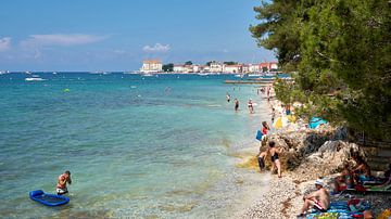 Strand met vakantiegangers aan de kust van de historische havenstad Porec aan de Adriatische Zee in  van Heiko Kueverling