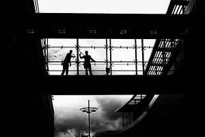 Silhouet van ramenwassers in Mosae Forum