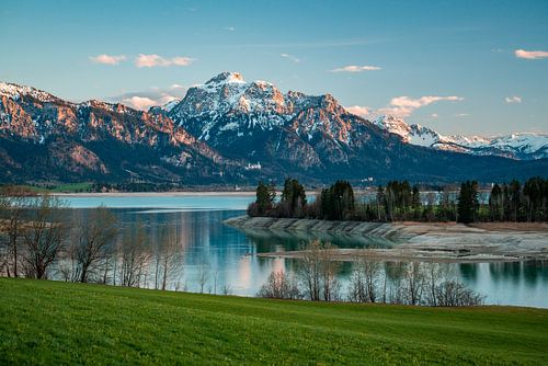 Zonsondergang boven de Forggensee met zicht op de Säuling en het kasteel Neuschwanstein