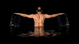 A man standing inside the water and spreads his arms by Markus Gann