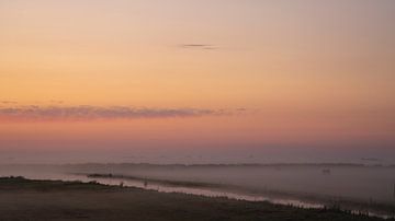 een prachtige zonsopkomst op een vroege ochtend vol laag hangende mist van Hans de Waay