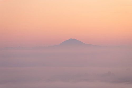 Hohenstaufen in een zee van mist met delicate kleuren bij zonsopgang.