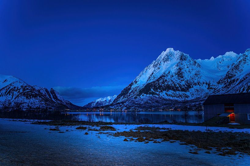 Avond met weerspiegelijng van sneeuw en bergen in het fjord. van Erwin Floor