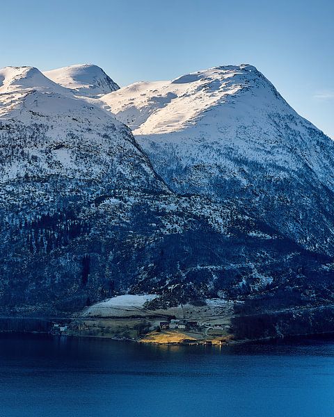 Sun illuminates a small farm below the towering mountains by qtx