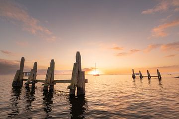 Un bateau navigue au coucher du soleil