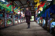 Jonge man in traditionele kleding op loopbrug met gebedsvlaggen in Thimphu Bhutan. Wout Kok One2expo van Wout Kok thumbnail