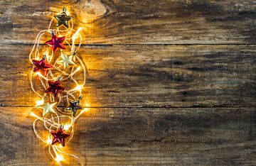 Kerstverlichting en ornamenten rand op houten achtergrond van Alex Winter