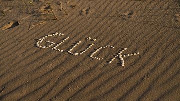 Mit Muscheln als Symbol des Glücks am Strand der Ostsee in den Sand gelegt von Martin Köbsch