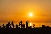 Zonsondergang op het strand, silhouetten.