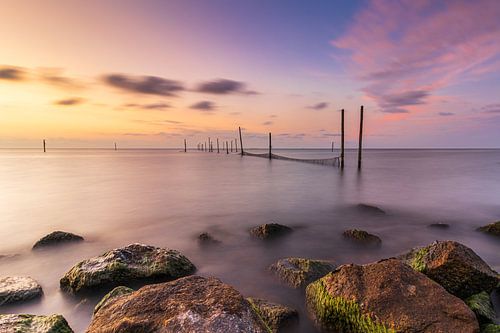 Visnetten in het IJsselmeer bij een kleurrijke rustige zonsondergang